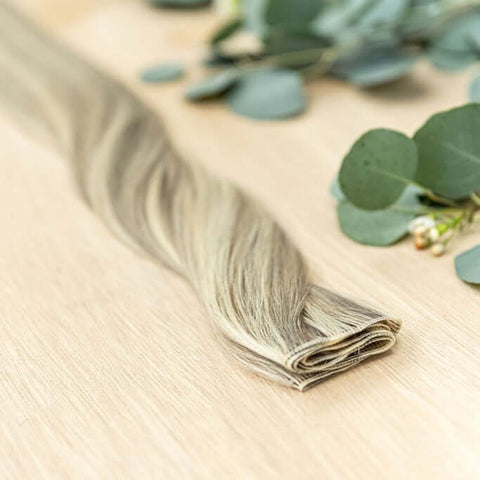 ALDER HIBER WEFT Alder Hiber Weft is a 22" piano weft featuring natural-toned level 7 ash and neutral level 10 warm blonde shades. These wefts offer customization options, including custom sizing, cut, and a seamless fine root base without a return edge.