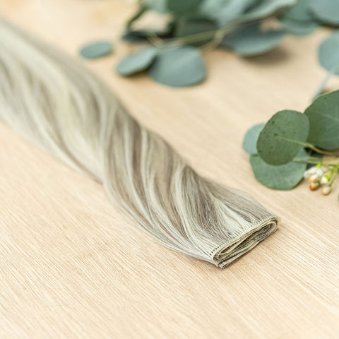 BIRCH HIBER WEFT Birch Hiber Weft is a 22" piano weft featuring natural-toned level 7 ash and neutral level 10 ash blonde. These wefts offer customization options, including custom sizing, cut, and a seamless fine root base without a return edge. The Hibe