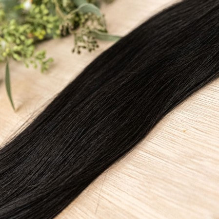 EBONY NATURAL TAPE Ebony weft is a 22" weft featuring natural level 1 dark brown with a warm undertone. Our natural tape hair extensions are carefully crafted to ensure a natural appearance and seamless blending. The hair is placed on the outside of the t
