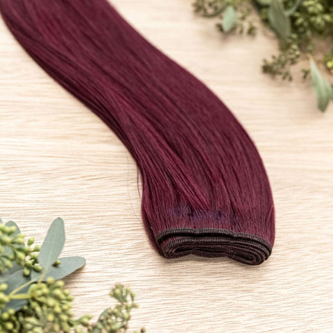 GARNET MACHINE WEFT 50g Garnet machine weft is a 22" weft featuring natural-toned vibrant level 5 red violet. These machine wefts offer the highest weft density, along with the flexibility to be custom sized, colored, and cut according to your preferences