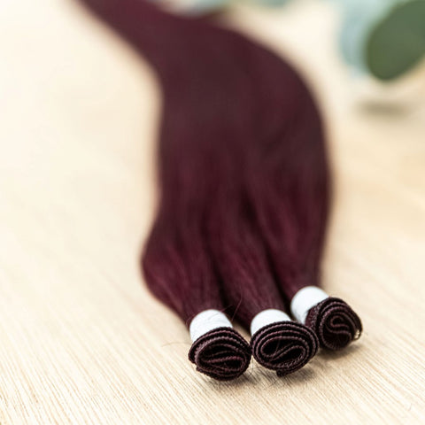 GARNET INDIVIDUAL HANDTIED WEFT Garnet is a 22" weft featuring natural level 5 vibrant red violet. Our hand-tied wefts are 22" in length and 11" in width, providing ample coverage for a voluminous result. Each individual weft weighs 20 grams, ensuring lig