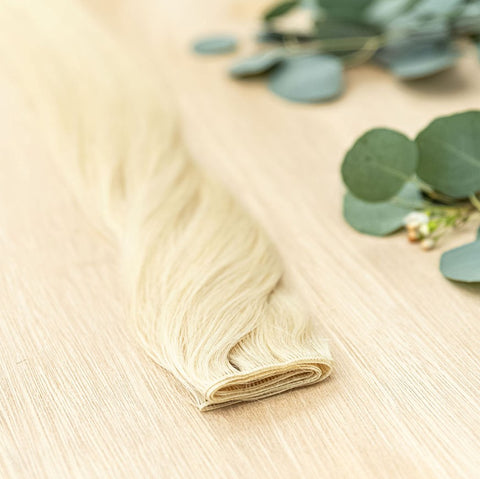 HAZEL HIBER WEFT Hazel Hiber Weft is a 22" weft is a natural level 9 pearlized warm blonde. These wefts offer customization options, including custom sizing, cut, and a seamless fine root base without a return edge. The Hiber Wefts are 22" in length and 3