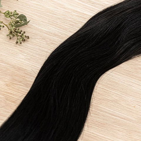 RAVEN NATURAL TAPE Raven weft is a 22" piano weft featuring natural-toned level 1 blue based black. Our natural tape hair extensions are carefully crafted to ensure a natural appearance and seamless blending. The hair is placed on the outside of the tape,