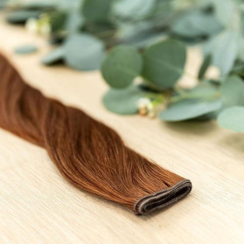 SAFFRON HIBER WEFT Saffron Hiber Weft is a 22" weft is a natural level 6 vivid warm copper. These wefts offer customization options, including custom sizing, cut, and a seamless fine root base without a return edge. The Hiber Wefts are 22" in length and 3