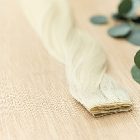 WILLOW HIBER WEFT Willow Hiber Weft is a 22" weft is a natural level 10 warm platinum blonde. These wefts offer customization options, including custom sizing, cut, and a seamless fine root base without a return edge. The Hiber Wefts are 22" in length and